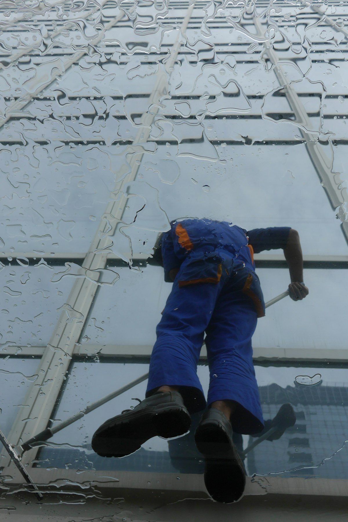 Fensterreinigung an einer Glasfassade fuer Gebaeudereinigung
